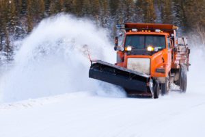 Snow plow clearing snow-covered road