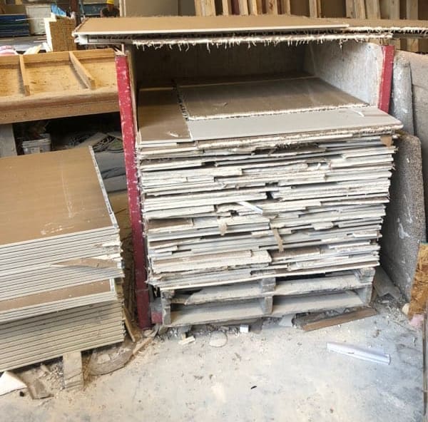 A pile of drywall sheets waiting to be recycled.